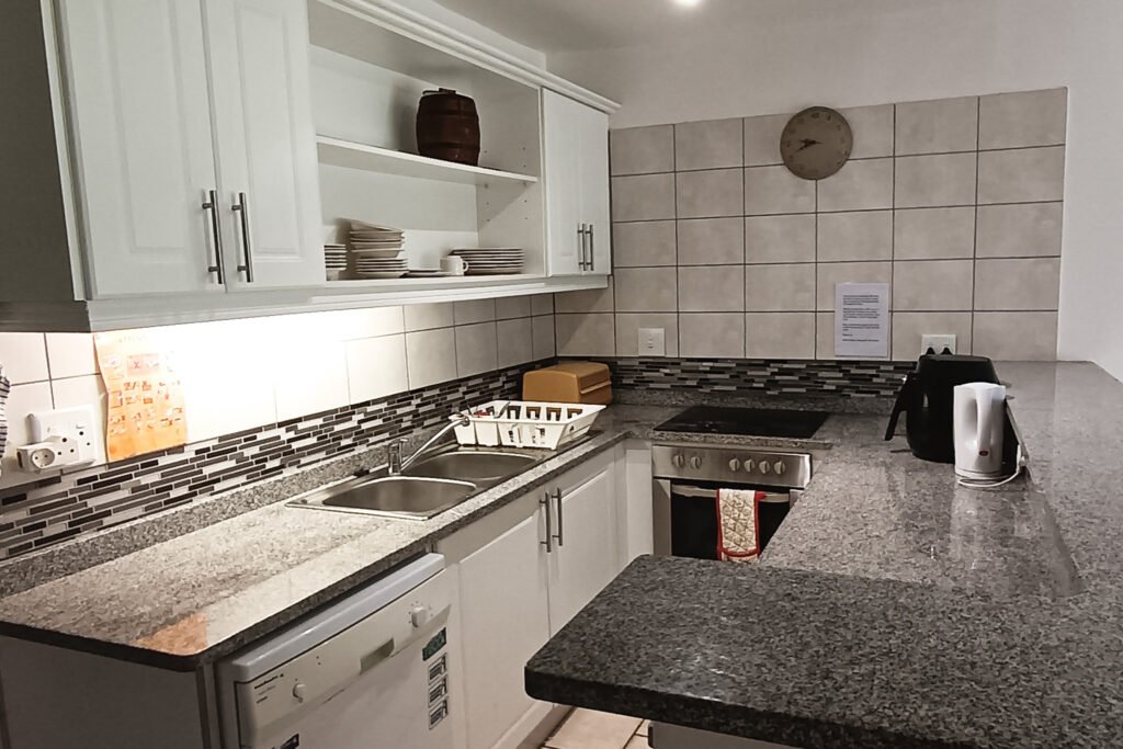 Modern kitchen with granite countertops and appliances.